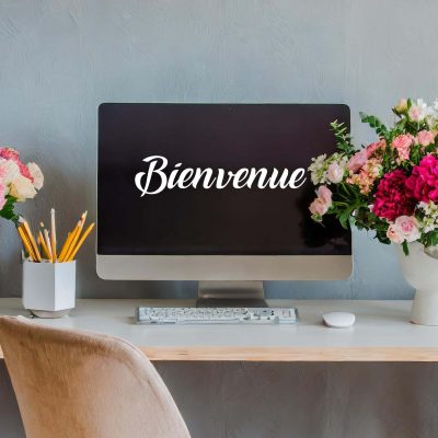 bureau moderne avec ordinateur, bouquet de fleurs et mot de bienvenue